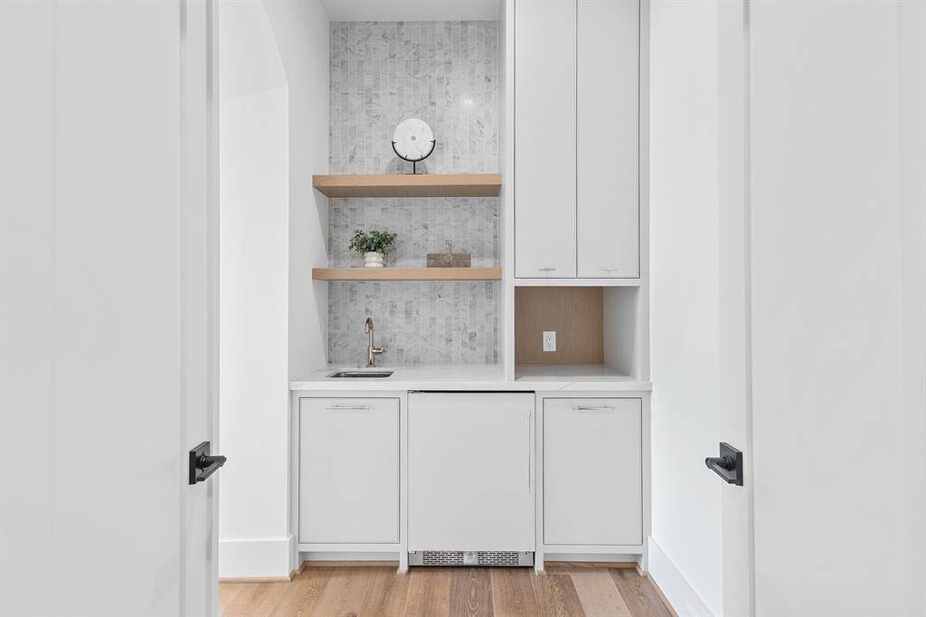 This private entryway to the primary suite is both functional and stylish, featuring a sleek wet bar and a mini fridge for ultimate convenience.