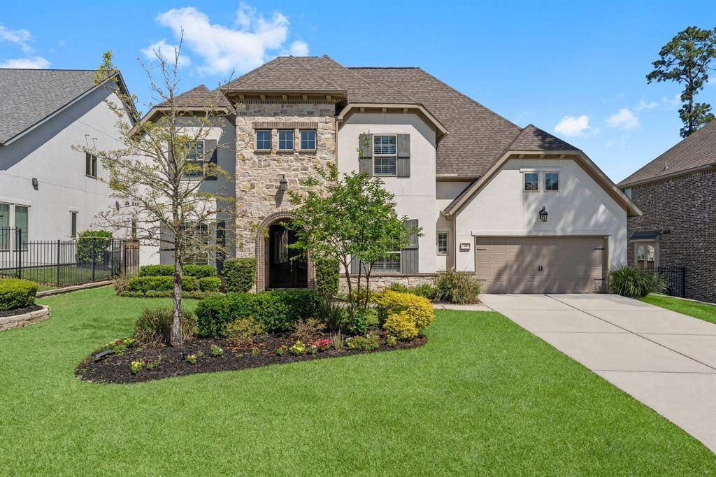Stunning curb appeal with stone and stucco elevation, beautifully manicured landscaping, and a welcoming arched entry. A true showcase of luxury in Creekside Park.