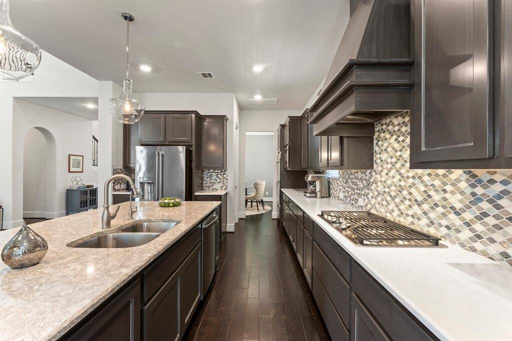 Abundant storage, double ovens, and a gas cooktop complete this gourmet kitchen, thoughtfully designed for both form and function.