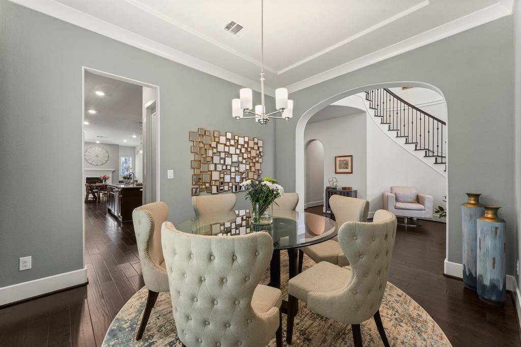 Classic archways and rich wood flooring lead into the formal dining area, blending traditional architecture with modern sophistication.