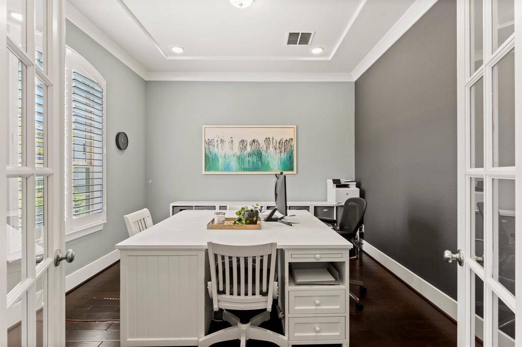 Tucked behind French doors, the home office offers privacy and function with custom trim, shutters, abundant natural light, and space for dual workstations.