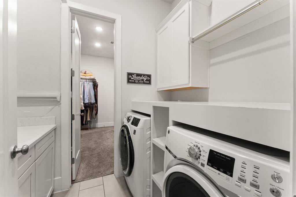 A bright and organized laundry room with upper storage and hanging space, providing both form and function.