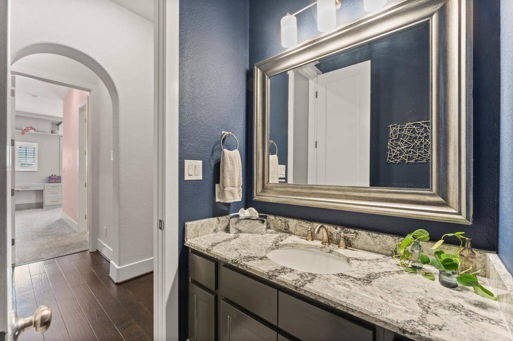 A rich navy accent wall enhances the granite vanity in this powder bath, creating a striking and stylish look.