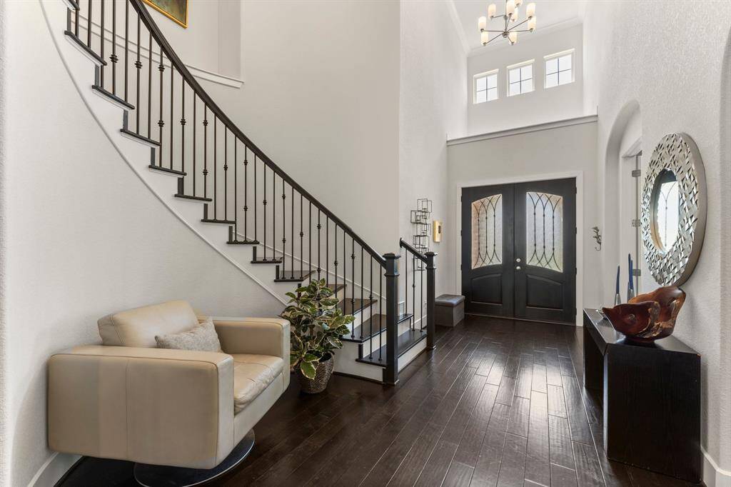 A sweeping staircase and natural light from clerestory windows create a dramatic and inviting entry. The perfect balance of sophistication and warmth.