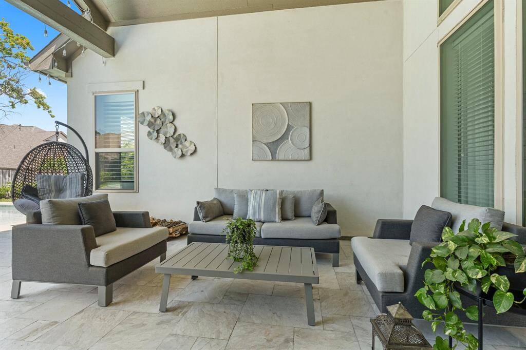 This spacious covered patio offers a refined canvas for outdoor entertaining, with room for both lounging and dining areas beneath the vaulted ceiling. Stylish finishes and neutral tones set the stage for elevated al fresco living.