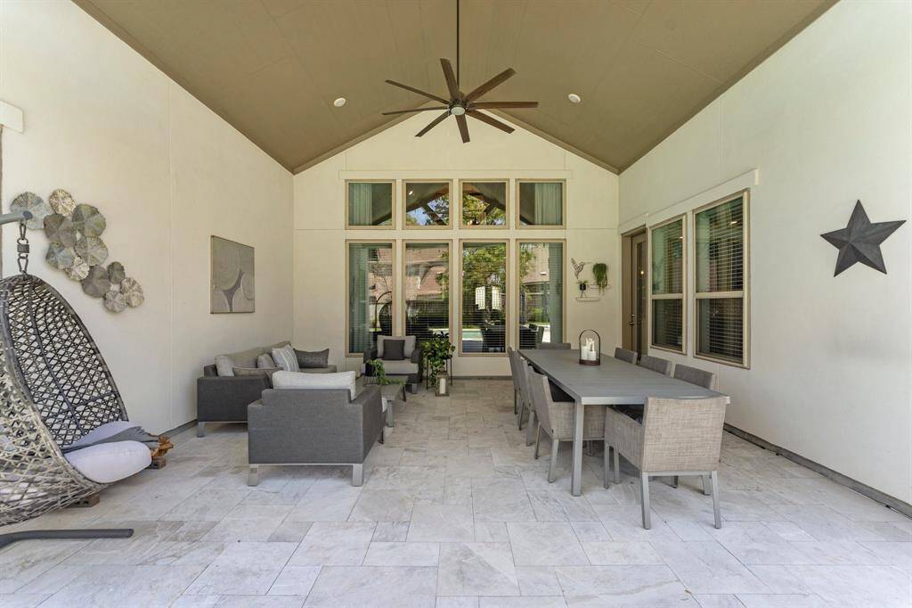 This spacious covered patio offers a refined canvas for outdoor entertaining, with room for both lounging and dining areas beneath the vaulted ceiling. Stylish finishes and neutral tones set the stage for elevated al fresco living.