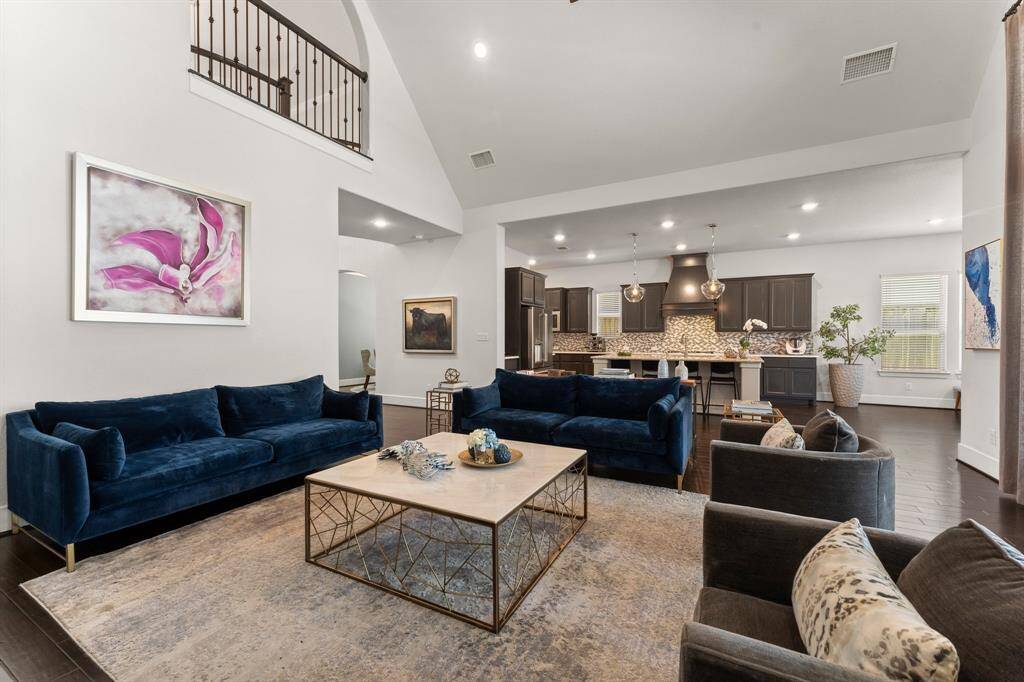 The heart of the home—this open-concept living space flows seamlessly into the chef’s kitchen, framed by elegant architectural details and a second-story overlook.