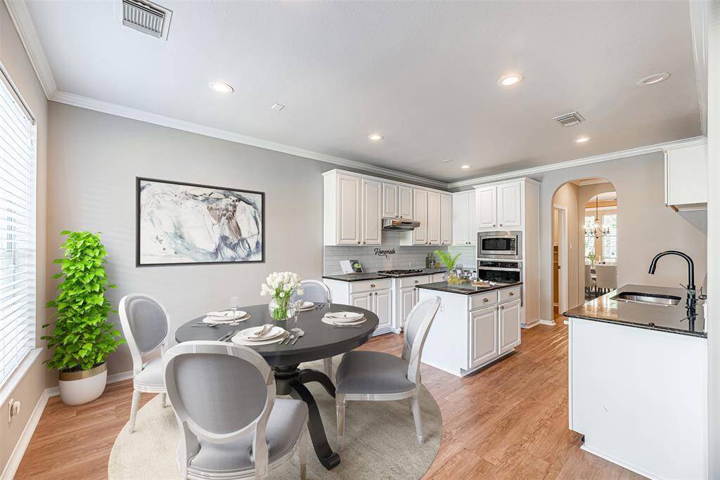 The breakfast room has the continued lvp flooring and picture window overlooking the backyard. *Virtually Staged*
