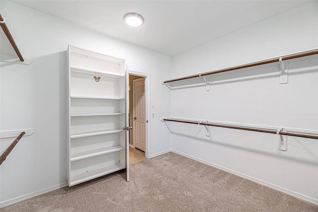 Another view of the walk in closet with built in shelves.