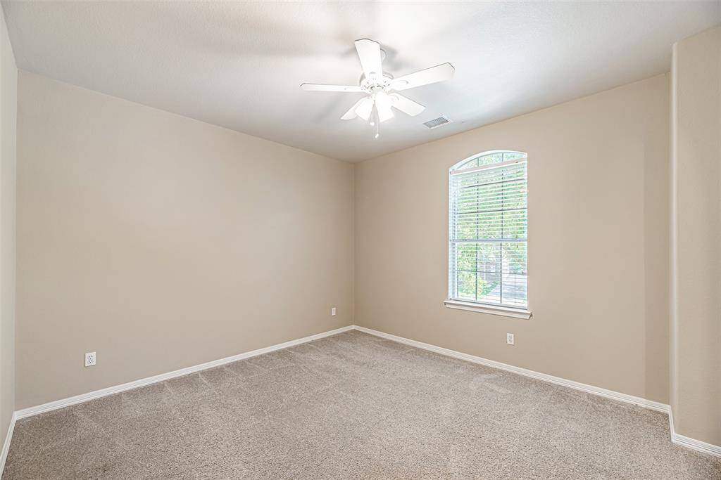Secondary bedroom upstairs with carpet, ceiling fan and picture window.