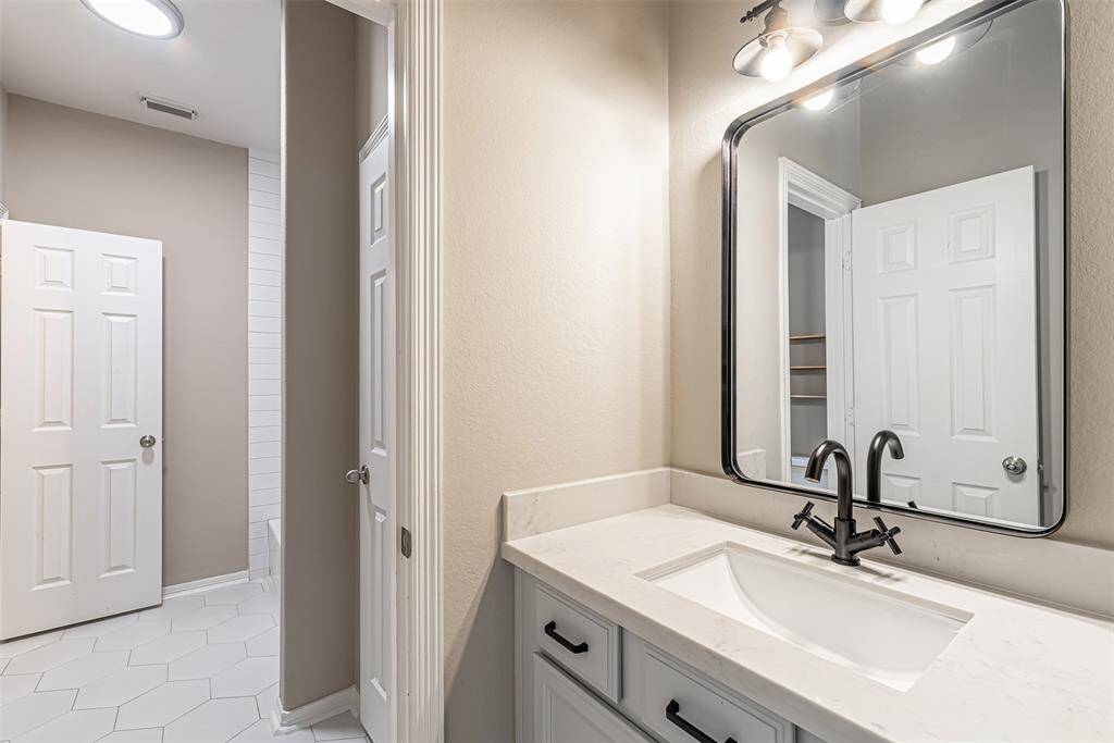 Other side of the hollywood bathroom with single sink vanity with quartz countertop and black finishes.