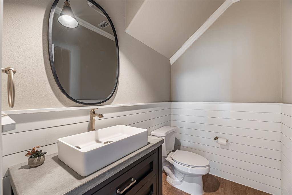 Updated half bathroom downstairs has single counter top rectangle sink and ship lap decorative wall.