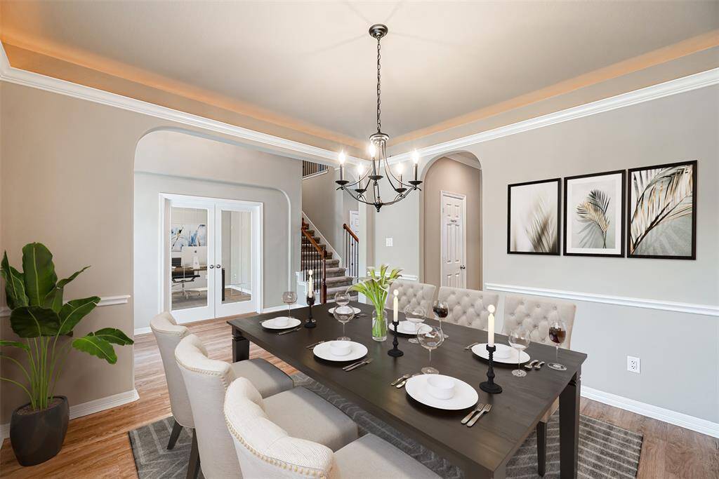 Dining room has lvp flooring, arched doorways and chair rail. *Virtually Staged*