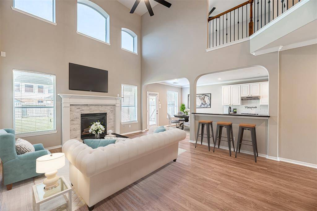 The family room stuns with high ceilings, large ceiling fan and double windows allowing for plenty of natural light. Family room also features a gas log fireplace with brick surround. *Virtually Staged*