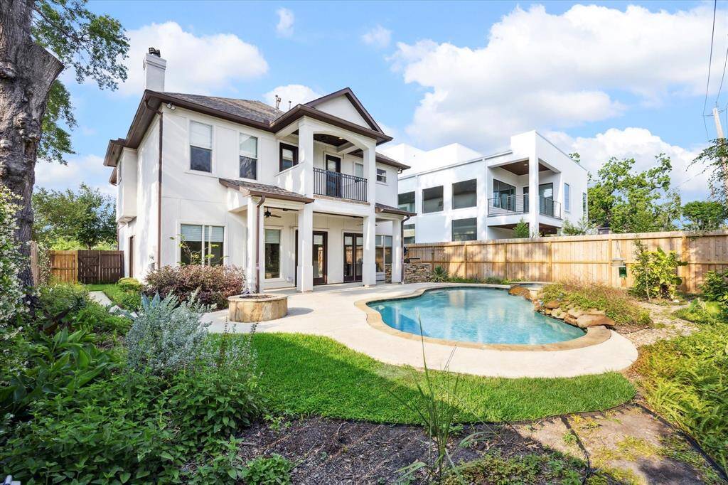 The rear elevation reflects the back balcony, covered patio, outdoor grilling center, and also the landscaped backyard with heated swimming pool and spa. The property is fenced for privacy and offers a serene outdoor living space ideal for relaxation and entertaining.