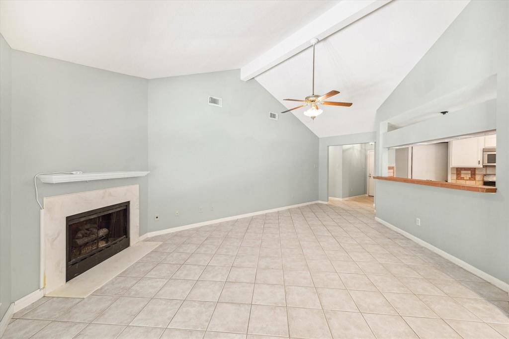 Spacious den with tile floor and vaulted ceiling
