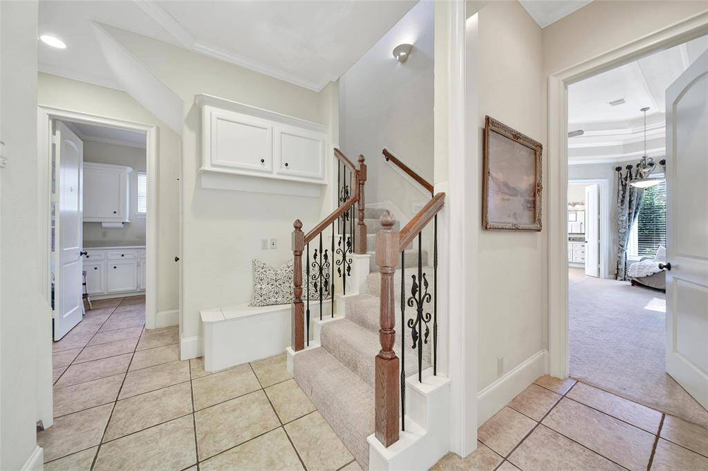 Hallway leads to the garage, laundry room, second stairway, and the primary bath. Room for a mud space near the stairs.