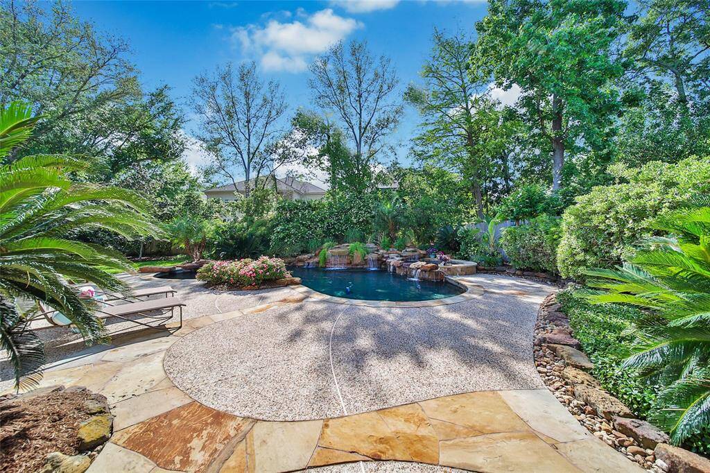 This backyard is stunning. So many bright colors from the beautiful plants, an inviting pool and hot tub and privacy from the neighbors because of the great landscaping.