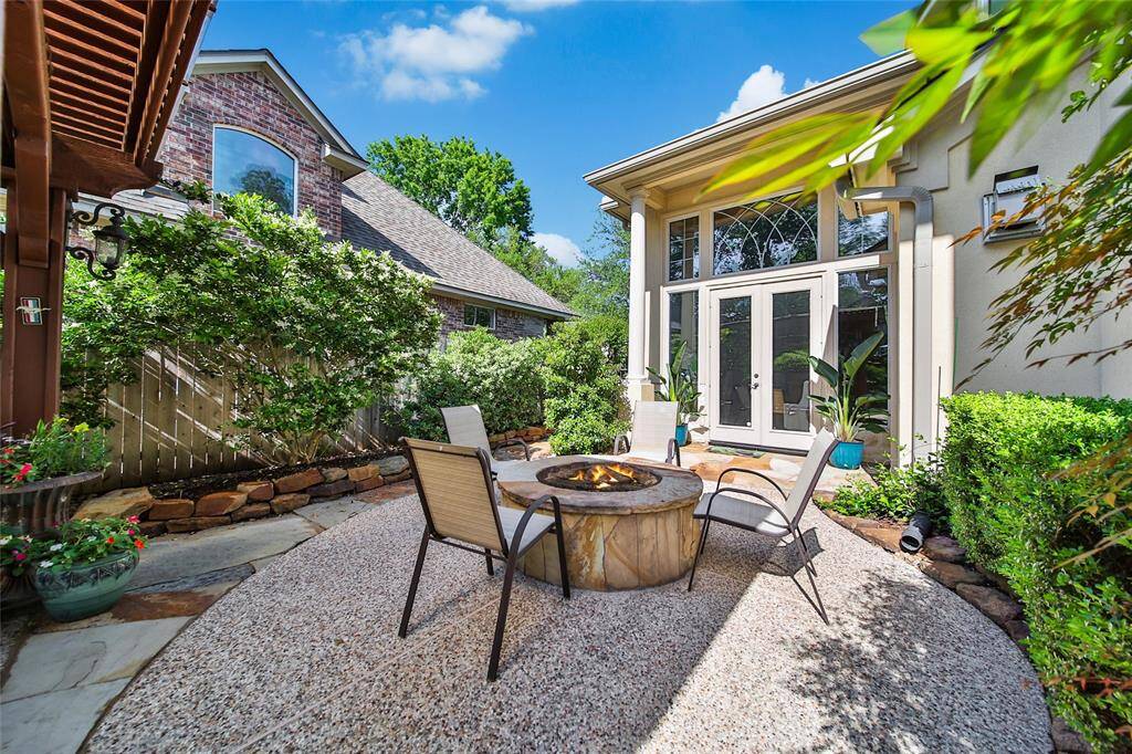 View of the fire pit from the pergola. The double doors pictured here lead to the formal living room.