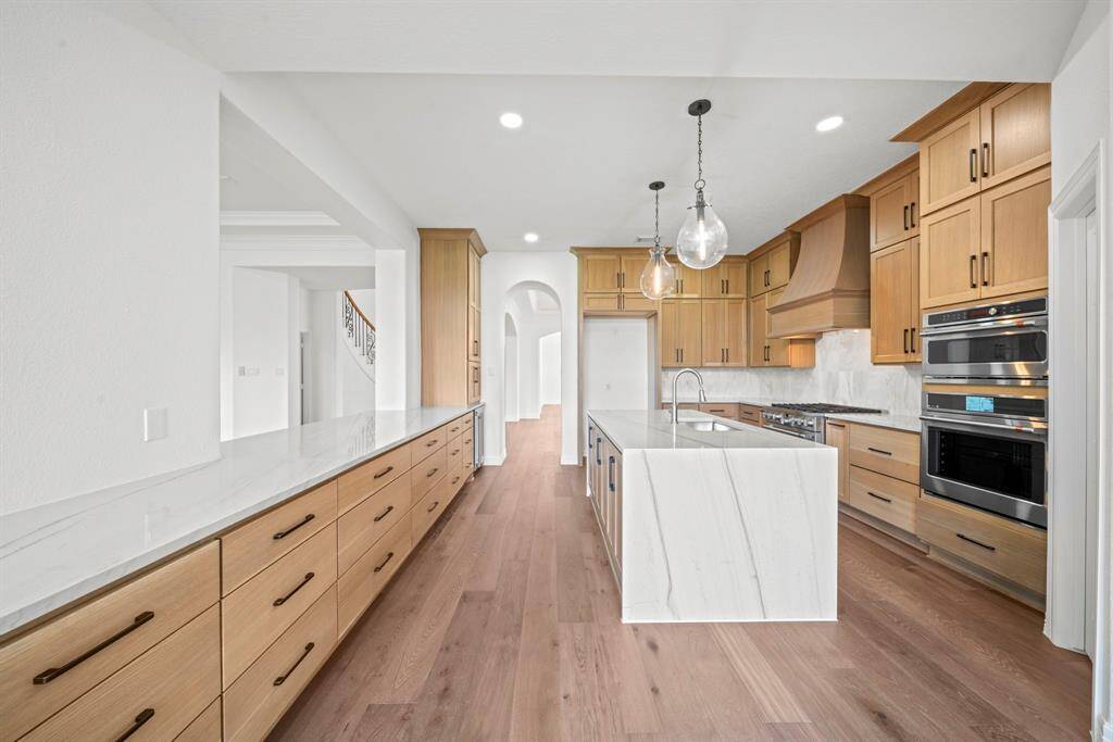 Island kitchen with waterfall marble counters and pass through counters to the den