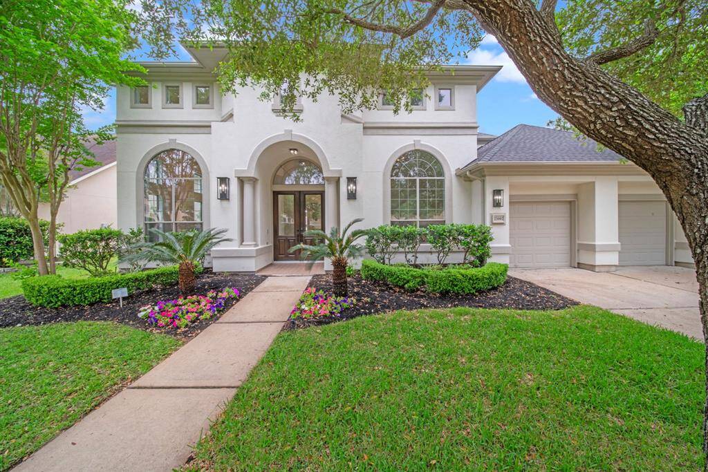 Stately stucco exterior with beautiful double doors and gas sconce lighting greets you.