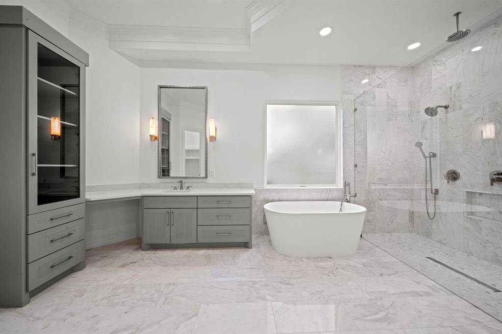 Marble tile and counters, custom cabinets, walk in closet and oversized shower