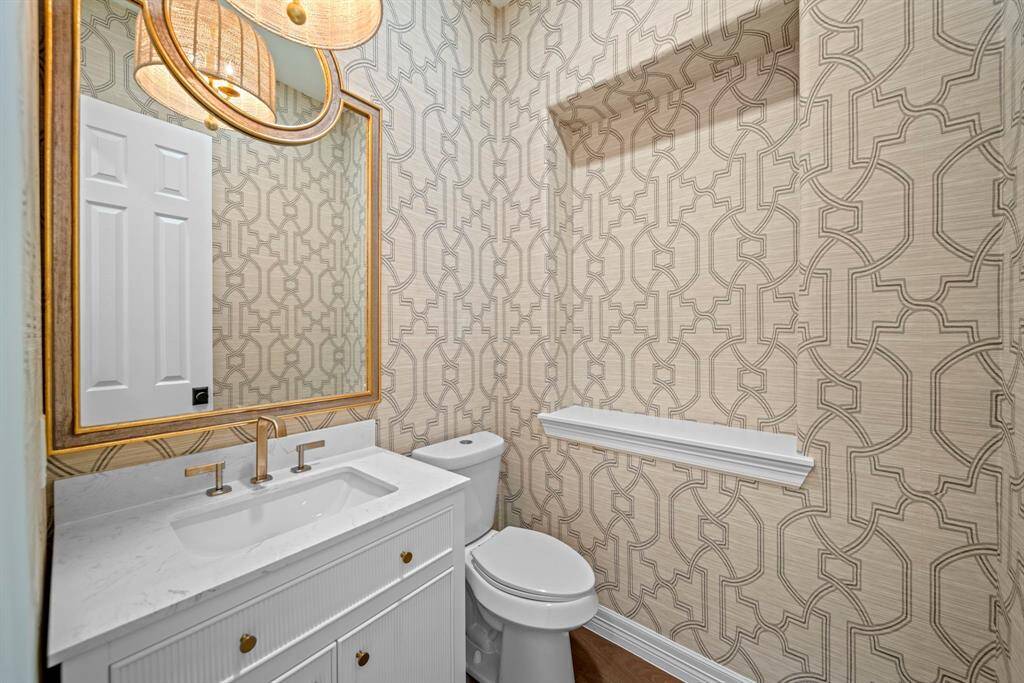 The powder room downstairs is elegantly appointed with custom wallpaper
