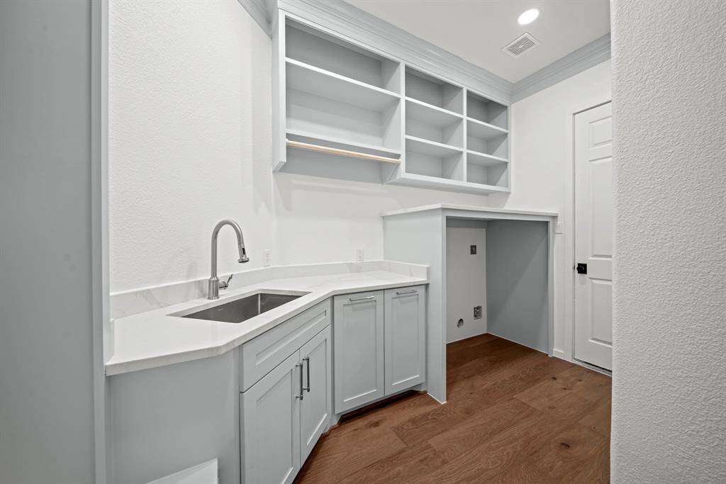 The utility room provides storage space, a sink and MUD room storage