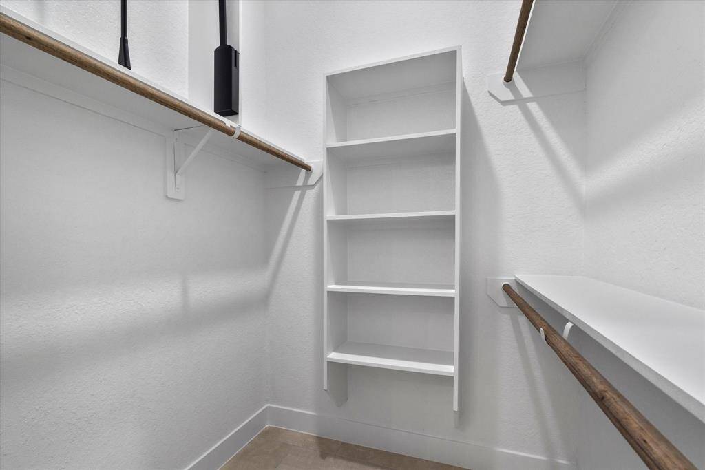 The walk-in closet includes additional shelving for organized and efficient storage.