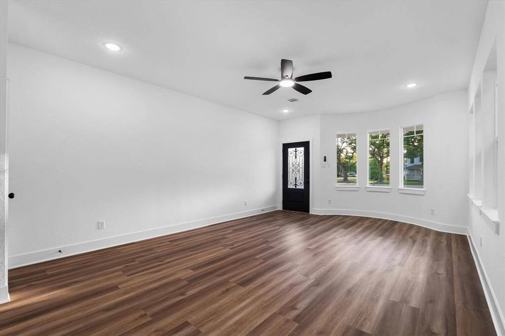Step into the inviting living area featuring sleek luxury vinyl flooring, a ceiling fan with recessed lighting. NO CARPET in this whole house!