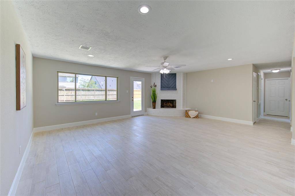 Beautiful living space resting under high ceilings with ample lighting and idyllic picture windows facing the backyard.