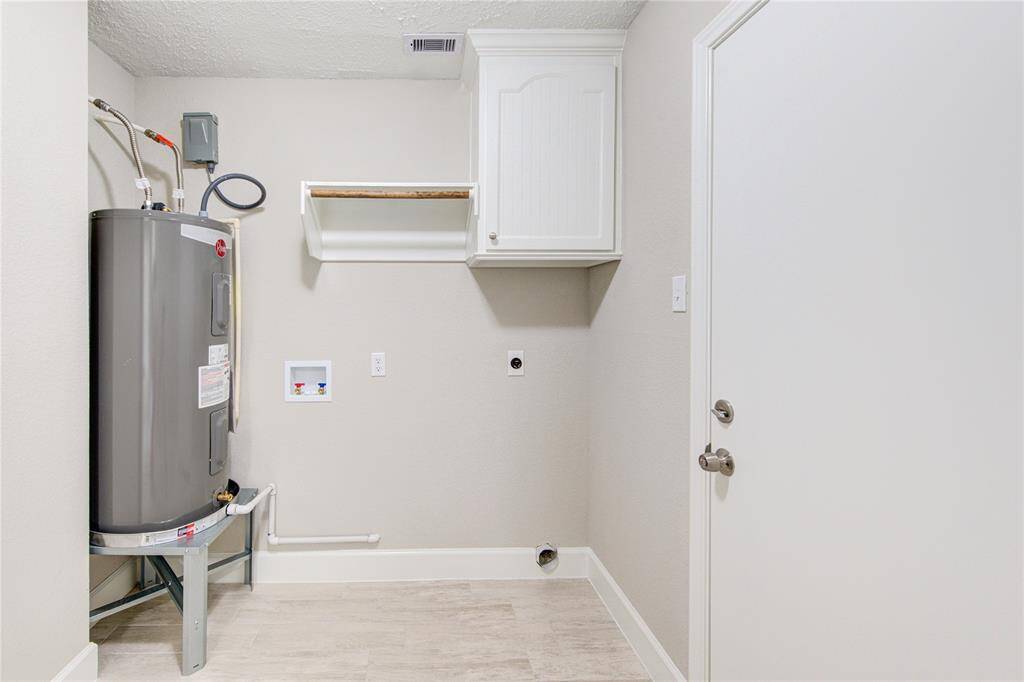 A nice sized utility room located downstairs, is ready to hold a full-sized washer and dryer, store your detergents and hang some clothes.