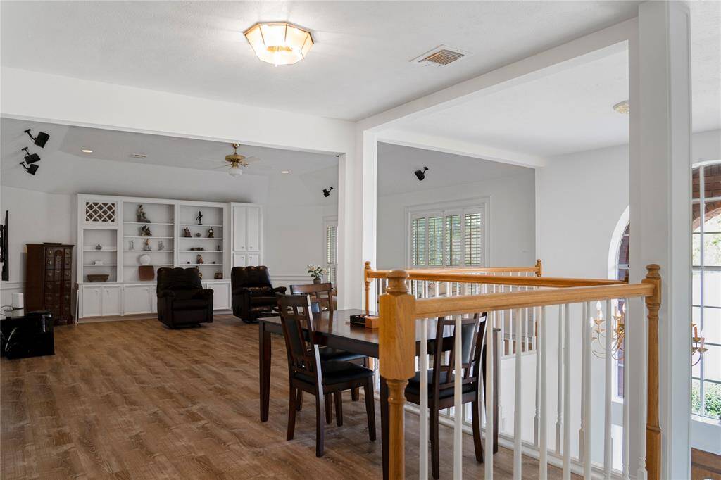 Bright and spacious game room with high ceilings, wood flooring, and large windows that let in plenty of natural light. Features a cozy seating area—perfect for entertaining guests or spending quality time with family.