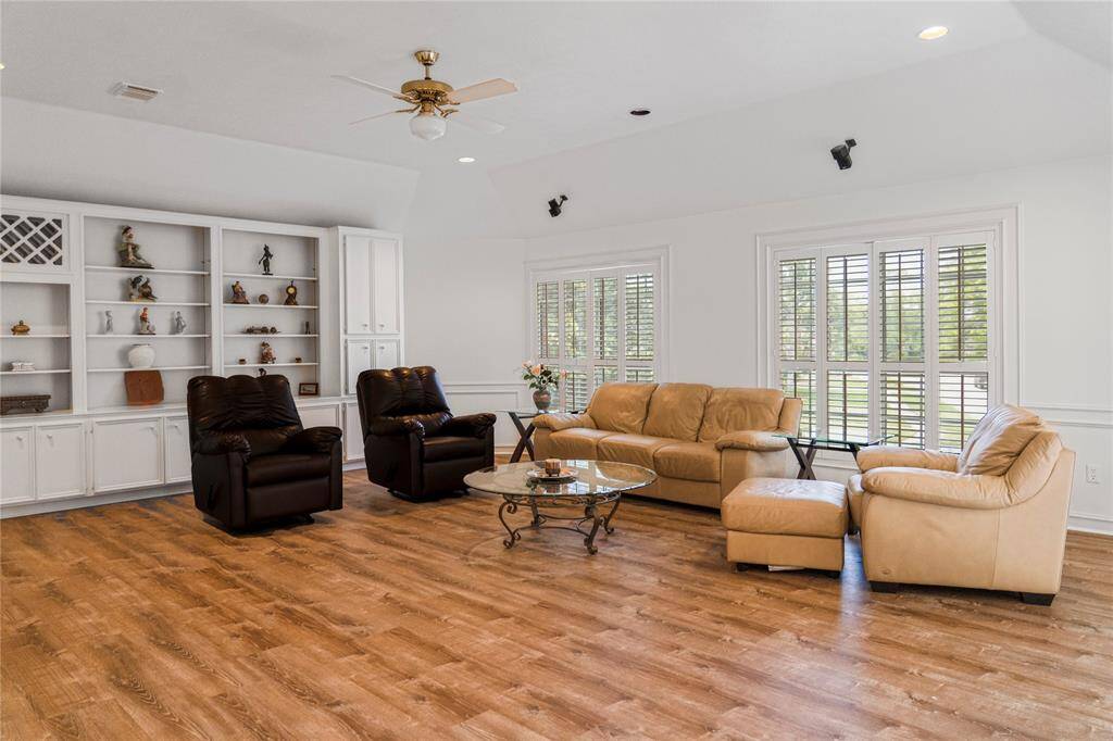 The perfect game room for board games, entertainment, and spending quality time with family and friends. It features built-in surround sound, plantation shutters, and elegant wooden shelving for added functionality and style.