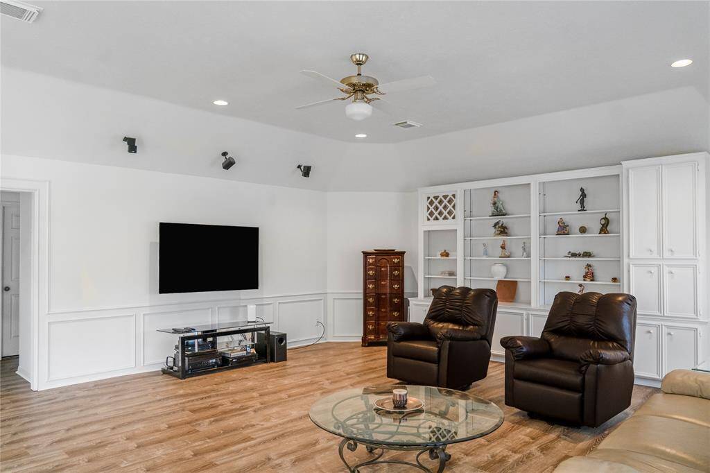 The perfect game room for board games, entertainment, and spending quality time with family and friends. It features built-in surround sound, plantation shutters, and elegant wooden shelving for added functionality and style.