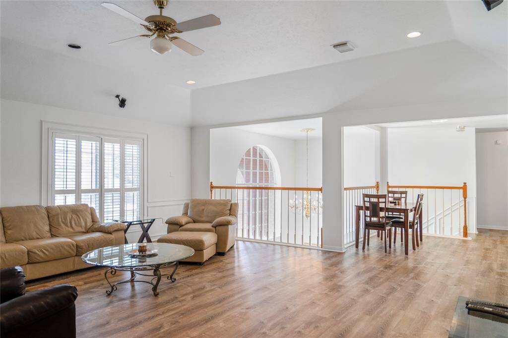 Bright and spacious game room with high ceilings, wood flooring, and large windows that let in plenty of natural light. Features a cozy seating area—perfect for entertaining guests or spending quality time with family.