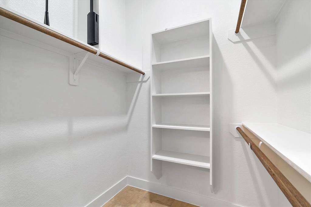 The en suite bathroom has a stand-up shower with black penny-tile floors, white walls and black fixtures. Plus, there’s frosted glass window that lets in natural light while still keeping things nice and private. Don’t forget about the linen closet!