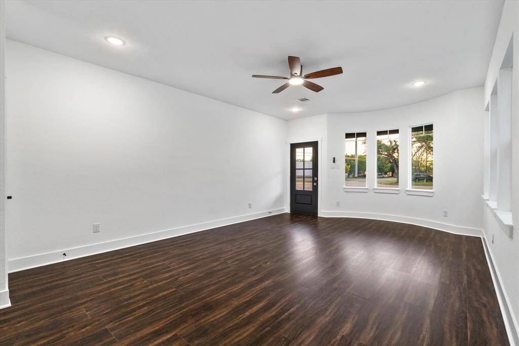 Step right into your cozy living space—complete with easy-to-clean dark luxury vinyl floors, soft recessed lighting, a breezy ceiling fan, and bay windows that brighten the room with natural sunshine.