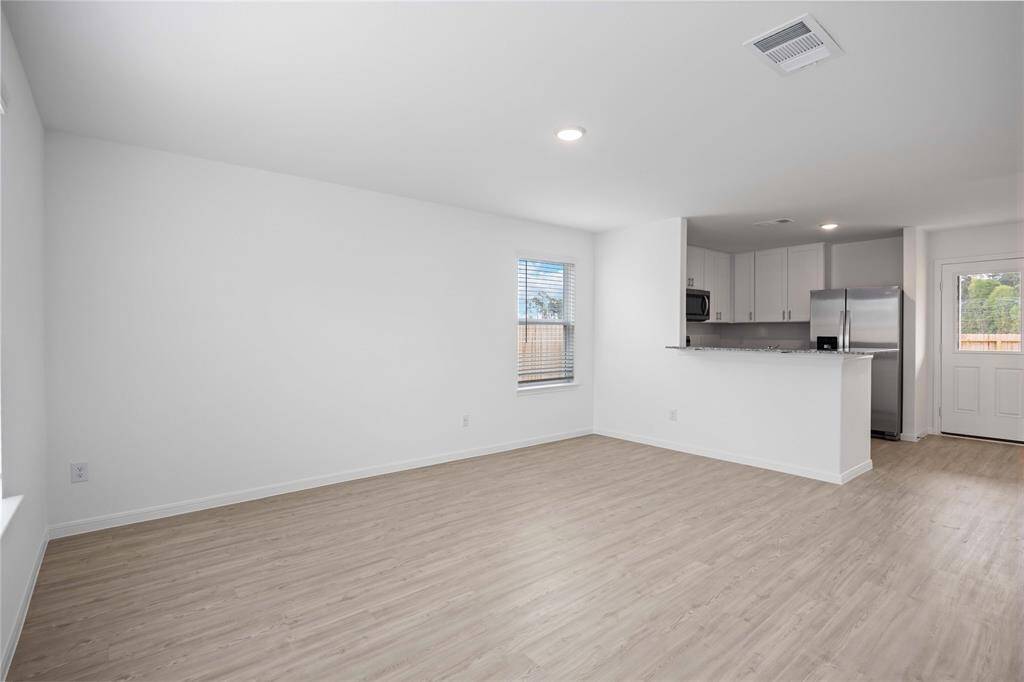 Living area to kitchen with breakfast bar.
