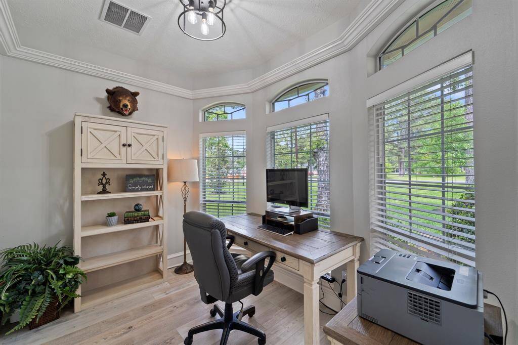 Just off the front entryway is this private home office with high ceilings, crown molding, and three large windows to enjoy the outdoor scenes.