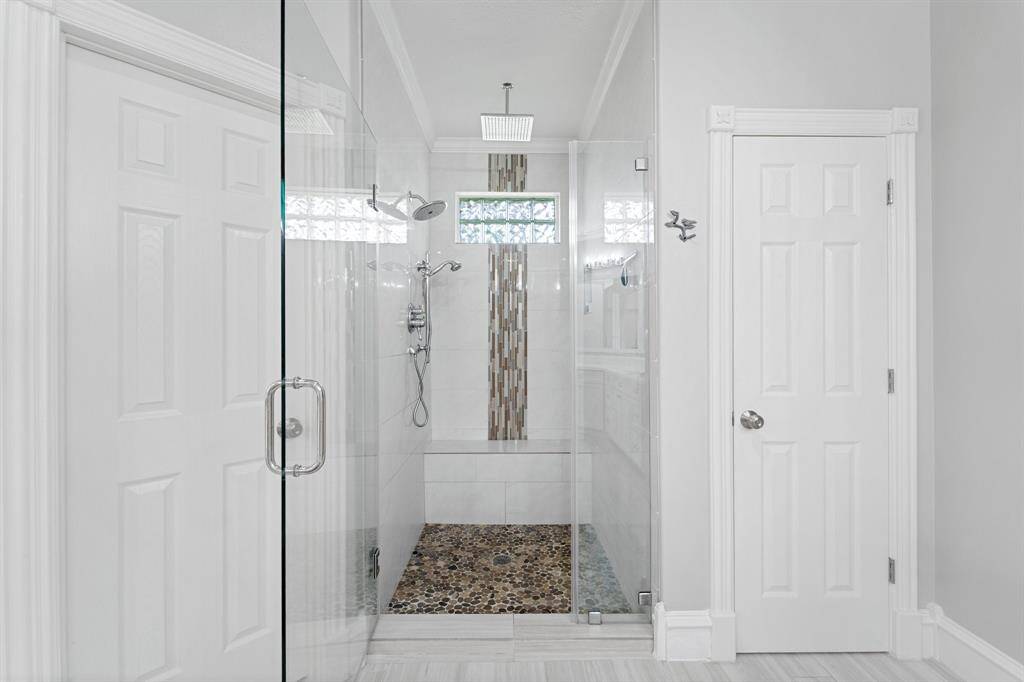Well thought out and designed shower with bench, rainforest and handheld shower system.