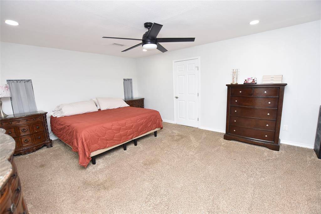 This expansive master suite offers plenty of room to comfortably accommodate multiple pieces of furniture.