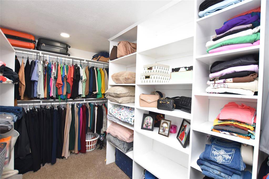 This master suite is complete with a large walk-in closet featuring built-in shelving for optimal organization.