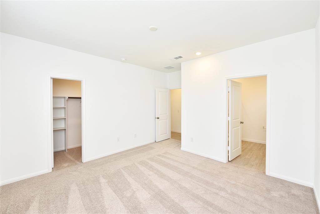 The spacious primary suite is tucked away at the back of the home for added privacy. It includes an en-suite bathroom and a generous walk-in closet—your own private retreat!
