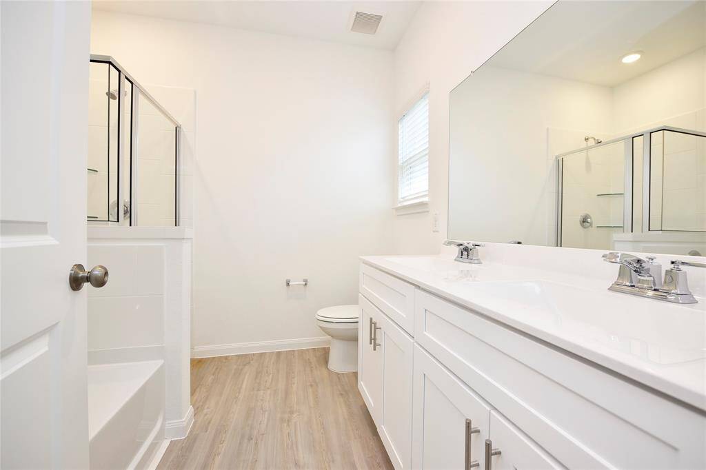 The primary bathroom features double sinks, a relaxing soaking tub, and a separate shower—perfect for both convenience and comfort.