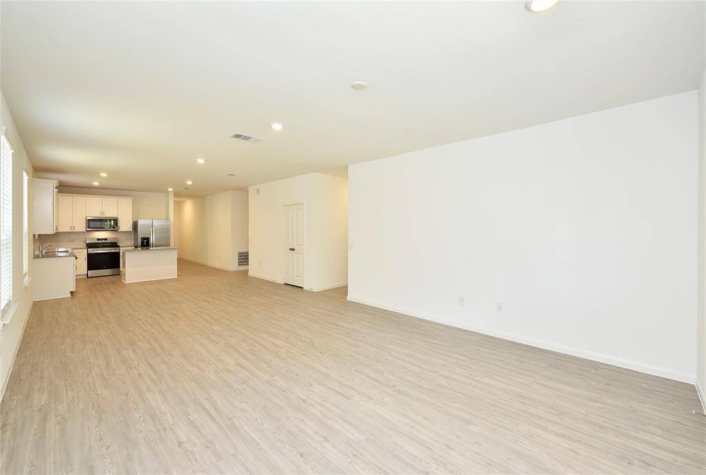 Here’s another look at the bright and spacious family room open to the kitchen and dining area—notice the natural light and open design.