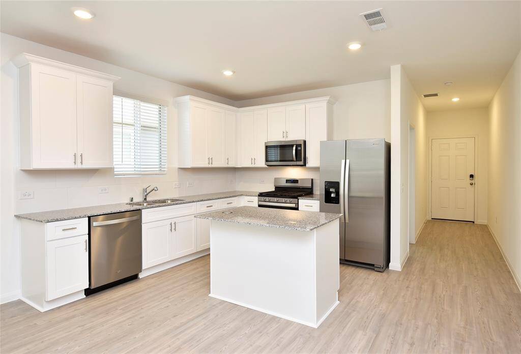 You’re going to fall in love with this open, bright kitchen—complete with a central island and  recessed lighting.