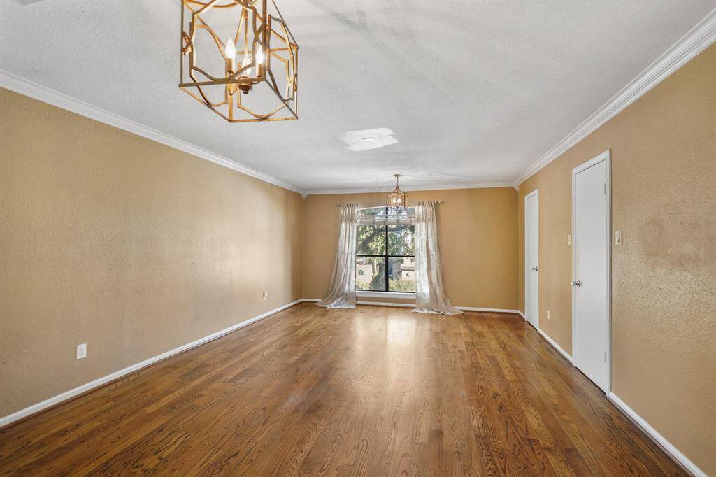 This primary bedroom is huge and offers crown molding and updated light fixtures.