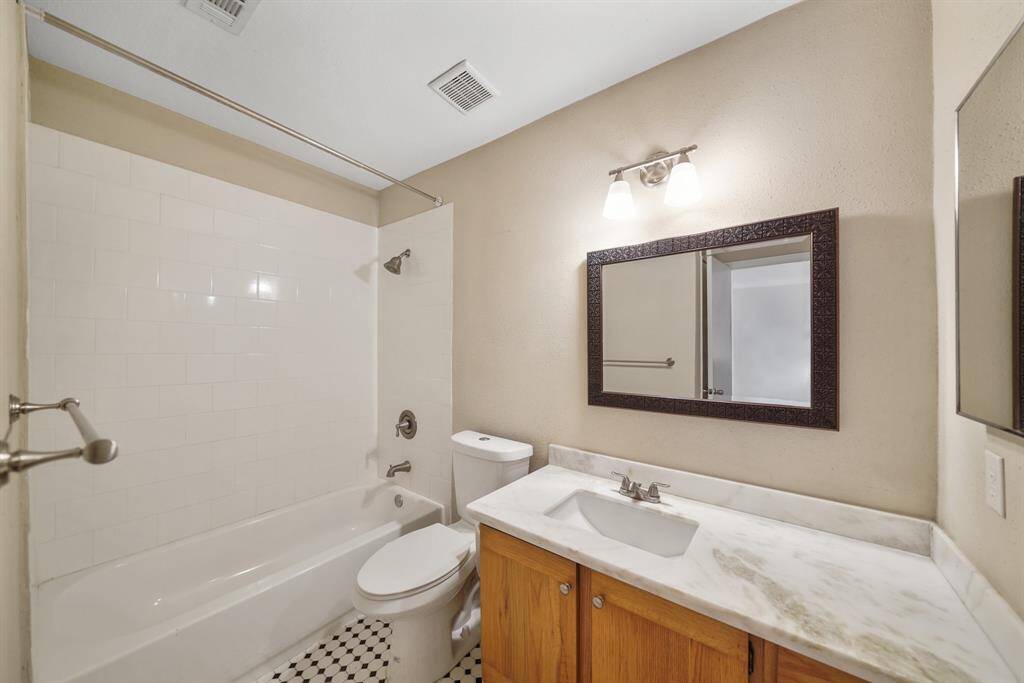 The second full bathroom upstairs offers a shower/tub comb and classic black and white tile flooring.