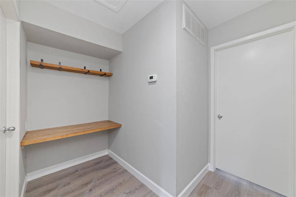 At the top of the stairs, a cozy nook has been transformed into a functional workspace, complete with a wooden shelf and desk, ideal for both work and storage. It’s the perfect spot to stay organized and productive!